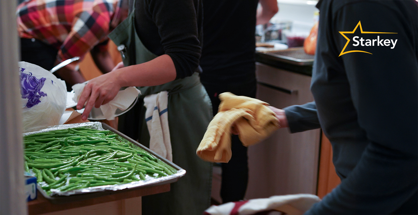 Image of two people working in the kitchen beside a pan of green beans